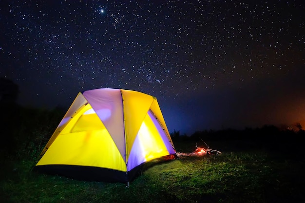 Photo une tente jaune sur le champ contre le ciel la nuit