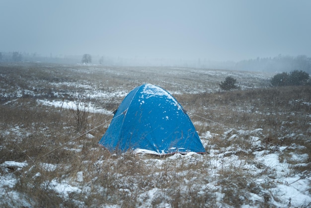 Tente solitaire dans le domaine l'heure d'hiver il neige