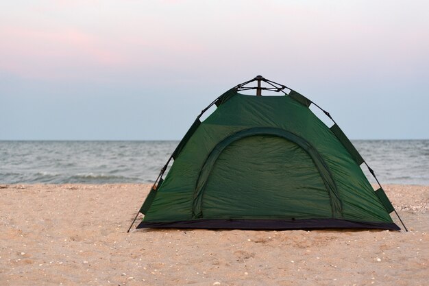 Tente touristique verte sur la plage de sable