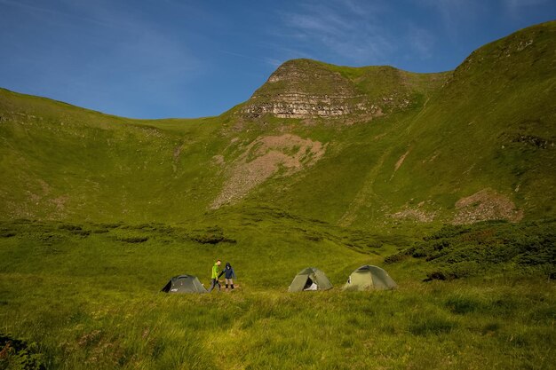 La tente verte pour le voyageur est assise sur un vaste terrain, surplombant le temps du soir. escapade en camping Pendant les longues vacances des voyageurs