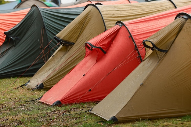 Photo des tentes de couleurs sur un champ sous la pluie