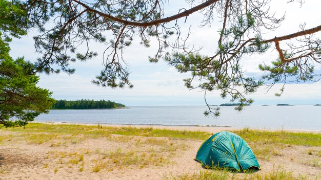 Tentes sur la rive sablonneuse du lac.