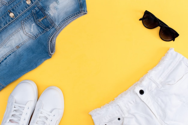 Tenue d&#39;été: t-shirt à rayures, short en denim et snickers blancs.