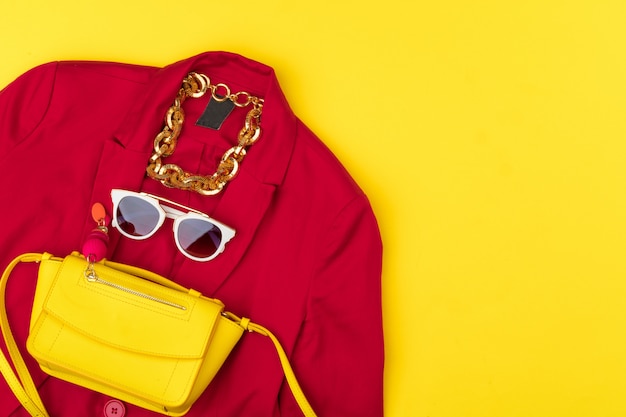 Tenue femme tendance avec accessoires sur fond jaune vif