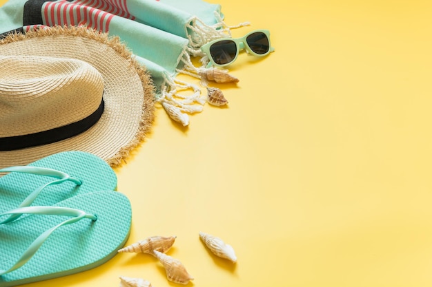 Tenue pour la plage et les vacances tropicales d'été chapeau de soleil en paille lunettes de soleil sur jaune