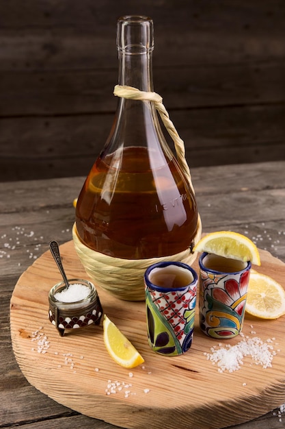 Photo tequila avec un citron et du sel sur une table en bois