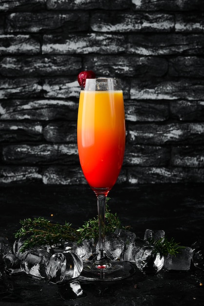 Tequila Sunrise cocktail alcoolisé Jus d'orange grenadine Sur le bar noir