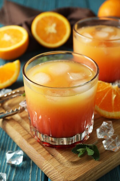 Tequila Sunrise cocktails et ingrédients sur table en bois