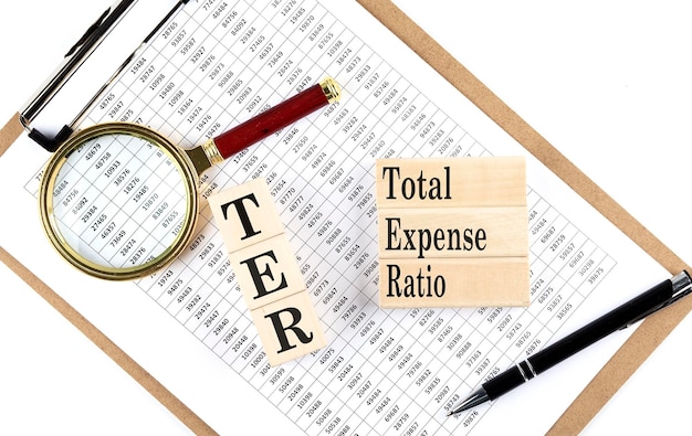 TER TOTAL FRAIS RATIO texte sur une cale en bois sur l'arrière-plan du graphique