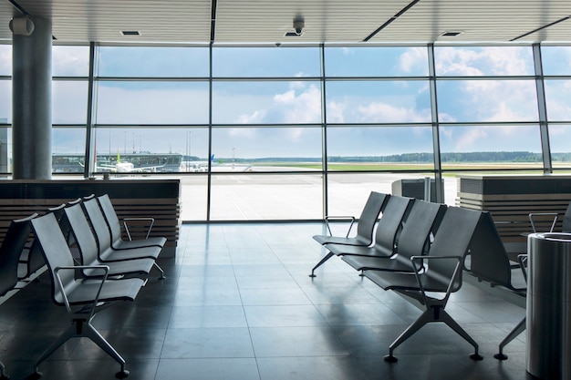Terminal de l'aéroport contemporain avec chaises vides dans un coin salon pour attendre le départ. Concept de voyage et de transport.