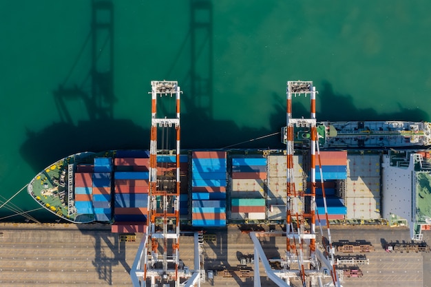 Photo terminal de porte-conteneurs, et grue de quai de porte-conteneurs au port industriel avec porte-conteneurs d'expédition, cargaison maritime de fret importation exportation service commercial logistique international