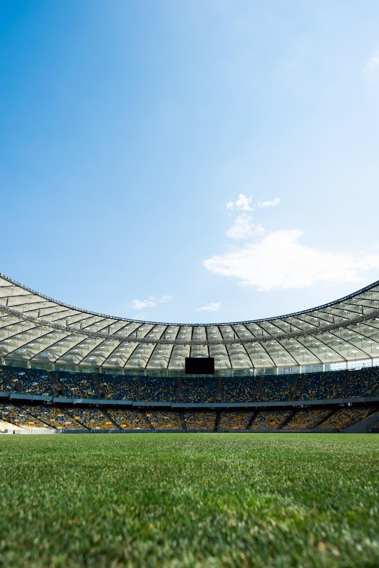 Photo terrain de football herbeux au stade aux beaux jours avec un ciel bleu