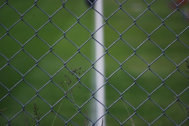 Photo un terrain de football vu à travers une clôture en chaîne