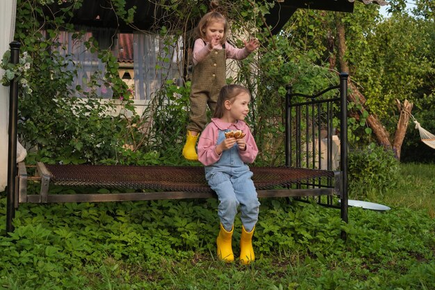 Photo terrain de jeu naturel sans jouets high-tech, ces sœurs trouvent leur terrain de jeu dans le jardin