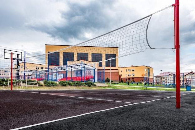 Terrain de volley-ball avec filet près du bâtiment de l'école.
