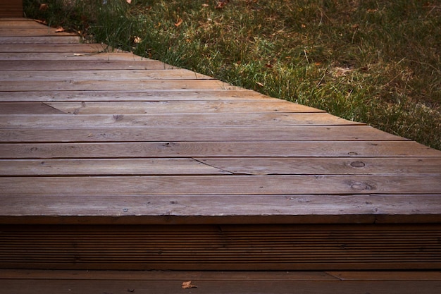 Une terrasse en bois avec une herbe verte en arrière-plan