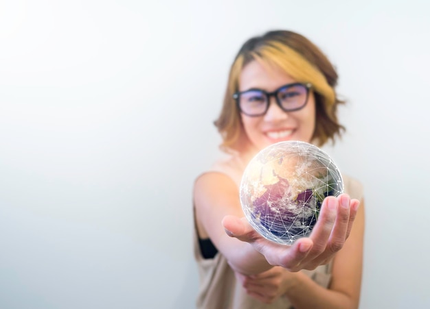 Terre dans la main Monde petit globe tenir et montrer par la main d'une femme asiatique heureuse sur fond blanc avec espace de copie Jour de la Terre Communication de connexion mondiale et futur concept de technologie de réseau