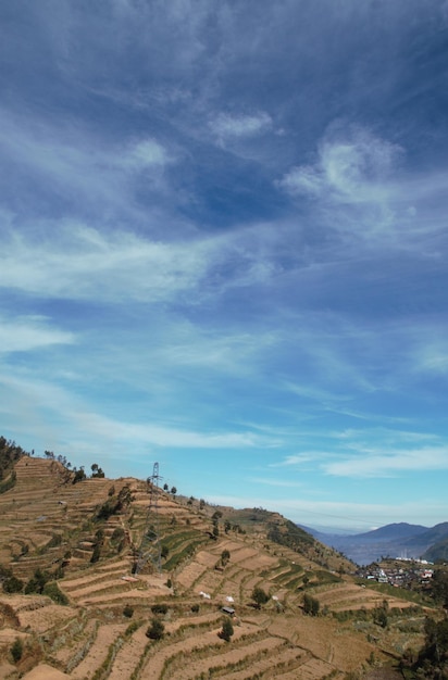 terres agricoles sur les pentes des montagnes pendant la saison sèche. sol sec. ciel bleu. ensoleillé.