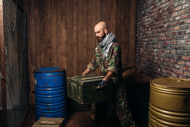 Terroriste En Uniforme Charge Des Boîtes De Munitions