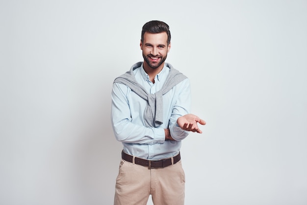 Êtes-vous heureux homme barbu charmant dans une chemise bleue sourit à la caméra tout en