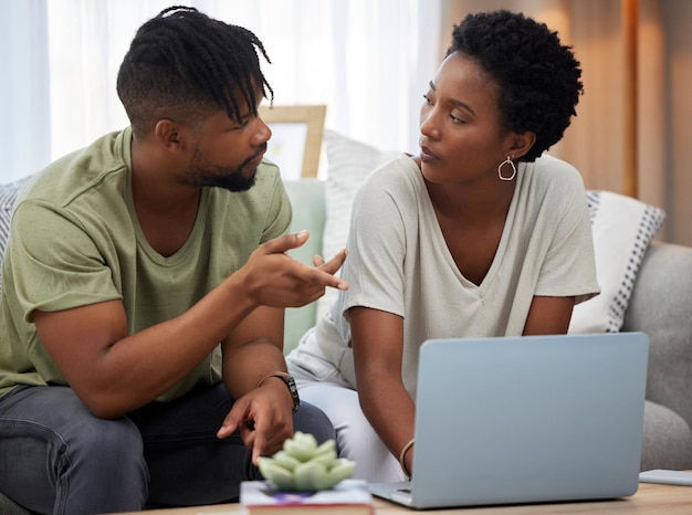 Êtes-vous sûr de vouloir regarder cette photo d'un jeune couple utilisant un ordinateur portable assis sur le canapé à la maison