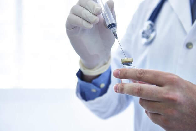 Êtes-vous vacciné Photo recadrée d'un médecin de sexe masculin remplissant une seringue de médicament