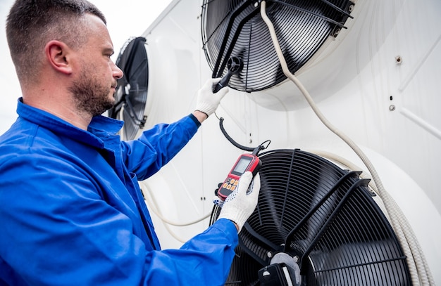 Test avec un anémomètre d'un ventilateur axial de l'unité de condensation