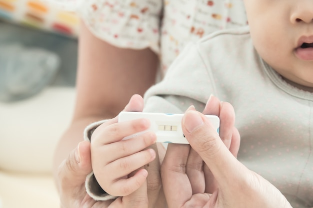 Test de grossesse avec enceinte positive chez les femmes main et main de bébé, Concept de famille