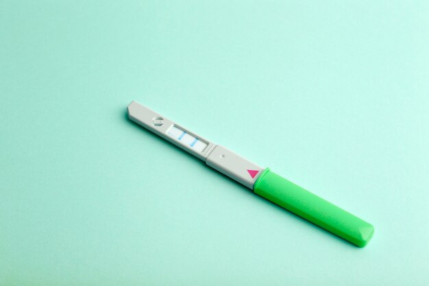 Test de grossesse sur un fond de couleur vierge. Grossesse, conception et santé des femmes. Naissance d'un concept de bébé