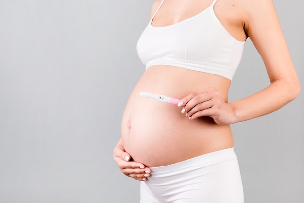 test de grossesse positif avec deux bandes contre la femme enceinte