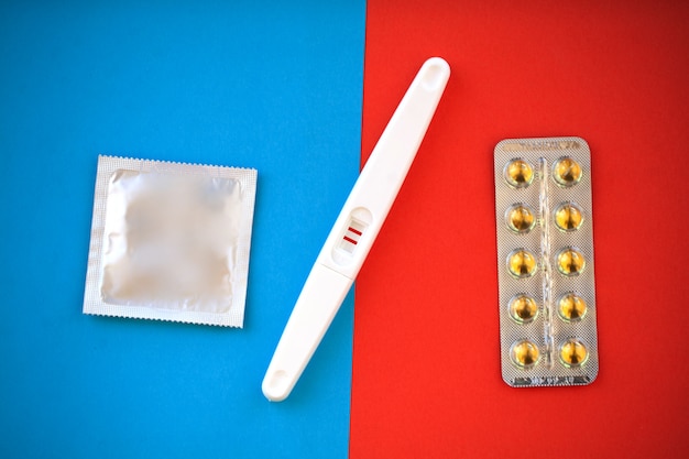 Test de grossesse. Le résultat est positif avec deux bandelettes et un préservatif avec contraceptif, pilule anticonceptionnelle, sexualité sans risque, concept de soins de santé