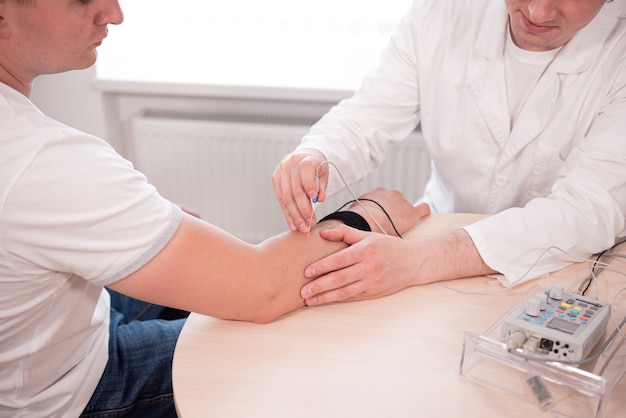 Photo test des nerfs du patient à l'aide de l'électromyographie au centre médical