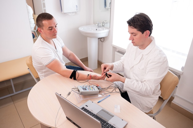 Test des nerfs du patient à l'aide de l'électromyographie au centre médical