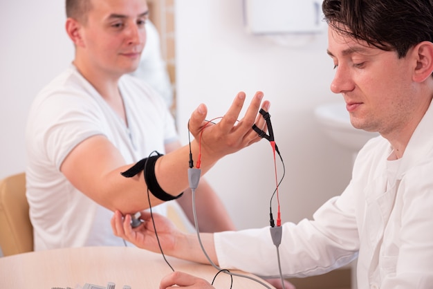 Test des nerfs du patient à l'aide de l'électromyographie au centre médical