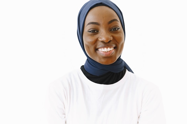 Tête D'une Belle Femme Musulmane Religieuse Satisfaite Avec Un Doux Sourire, Une Peau Sombre Et Saine, Porte Un Foulard Sur La Tête. Isolé Sur Fond Blanc.