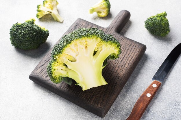 Tête de brocoli fraîche coupée sur une planche à découper sur une table en béton gris. Copiez l'espace.