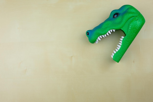 Tête de dinosaure vert en plastique avec la bouche ouverte