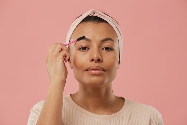 Photo tête et épaules portrait de belle femme métisse brossage des sourcils