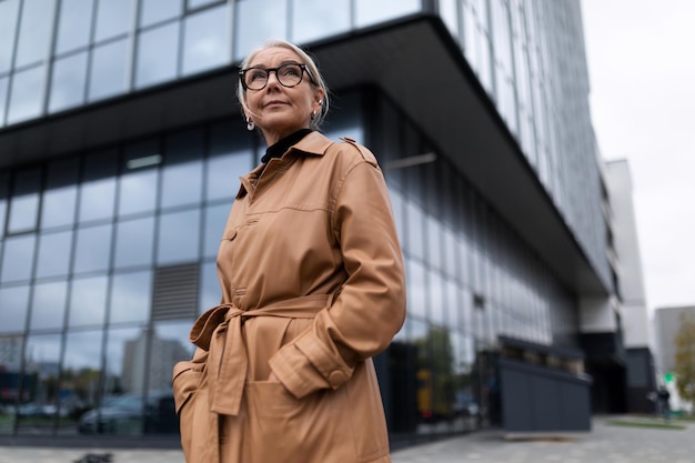 Tête de femme âgée réussie sur le fond de la façade d'un immeuble de bureaux moderne