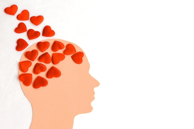 Une tête humaine remplie de cœurs sur un fond clair le concept d'un homme amoureux