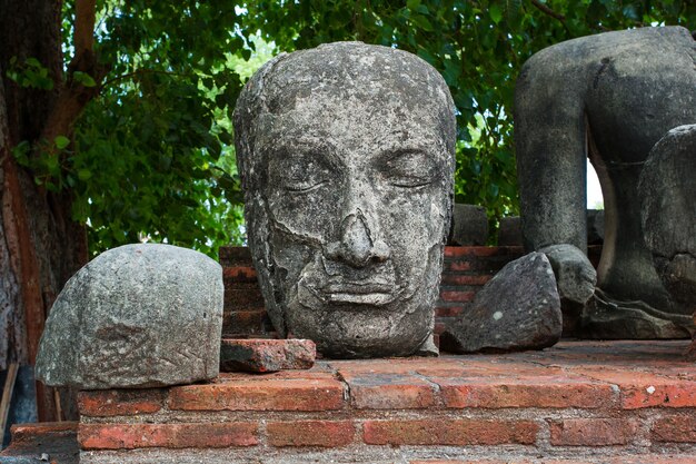 La tête d'une image de Bouddha en pierre sur une vieille clôture au temple Ratchaburana, province d'Ayutthaya Thaïlande