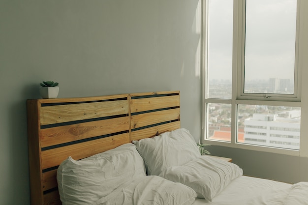 Tête de lit mezzanine en bois pin avec lit blanc.