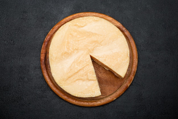 Photo tête ronde entière et morceaux de parmesan ou parmigiano