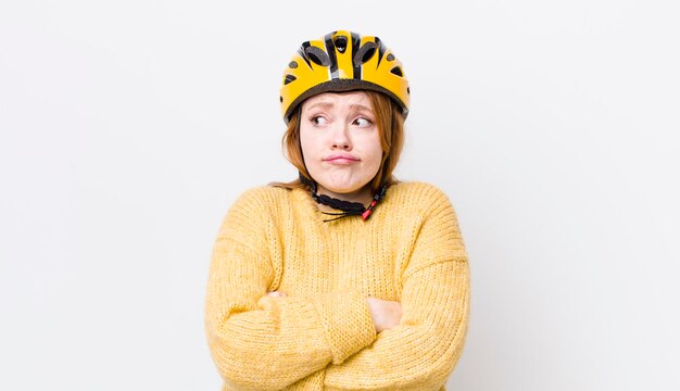 Tête rouge jolie femme haussant les épaules se sentant concept de cyclisme confus et incertain