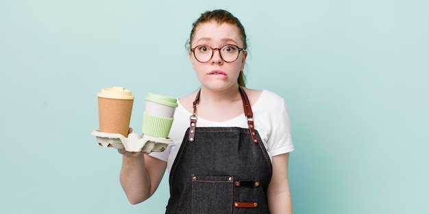 Tête rouge jolie femme à la recherche perplexe et confuse à emporter concept de café