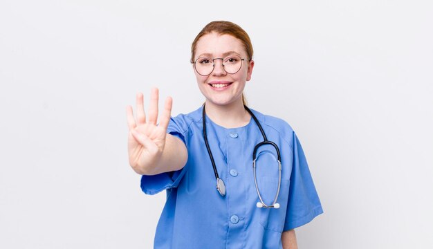 Tête rouge jolie femme souriante et sympathique montrant le concept d'infirmière numéro quatre