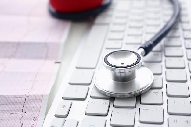 Photo tête de stéthoscope allongé sur un clavier blanc