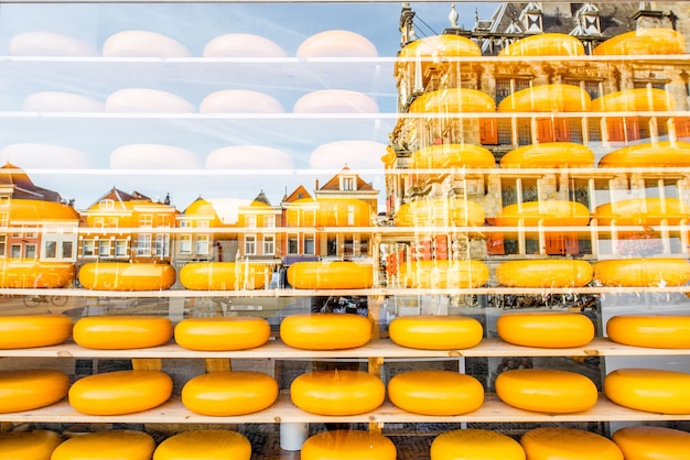 Têtes de fromage hollandais sur les étagères de la vitrine avec reflet de la ville de Delft aux Pays-Bas