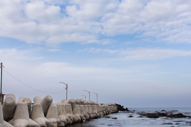 Photo un tétrapode en blocs de béton pour le brise-lames et la dissipation de l'eau des vagues empêche l'érosion à la jetée de pêche de la pêche dans la mer et l'océan de l'est du japon dans la ville de pohang à gyeongsangbuk ou au nord de gyeongsang en corée du sud