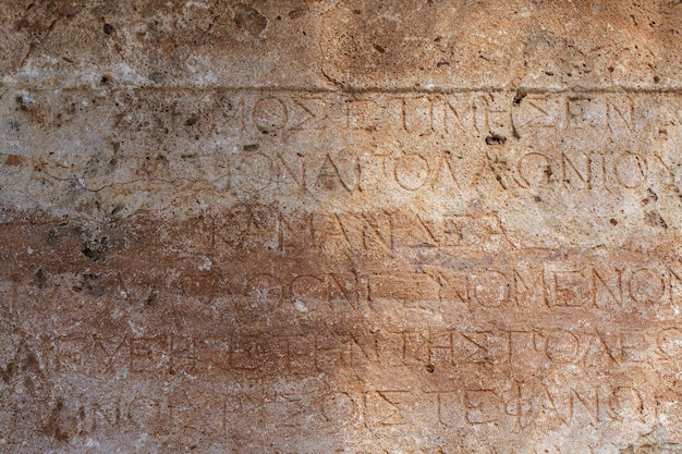 Texte antique grec ancien et inscriptions sur le mur de pierre du temple Alphabet de la culture grecque antique et concept d'histoire de fond d'écriture